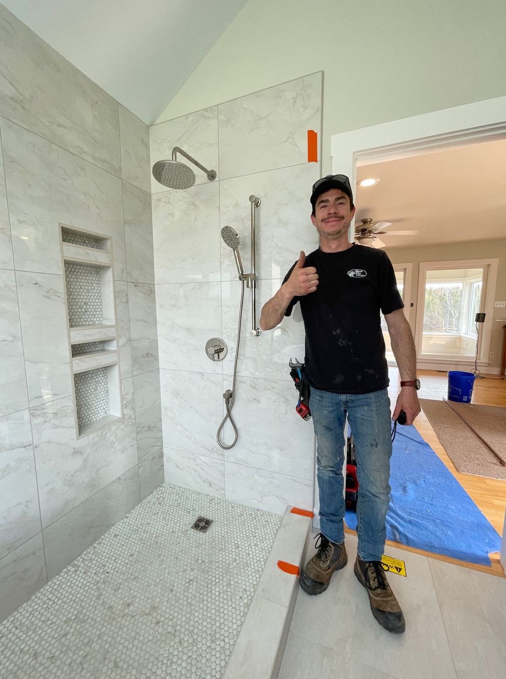 Plumber finishing a new tiled shower installation